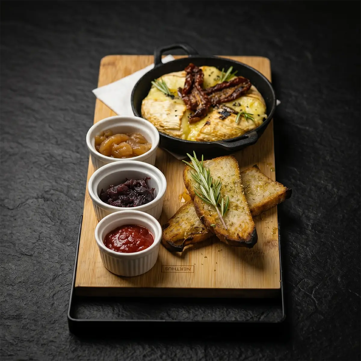 Baked camembert in a skillet with house chutneys and grilled focaccia