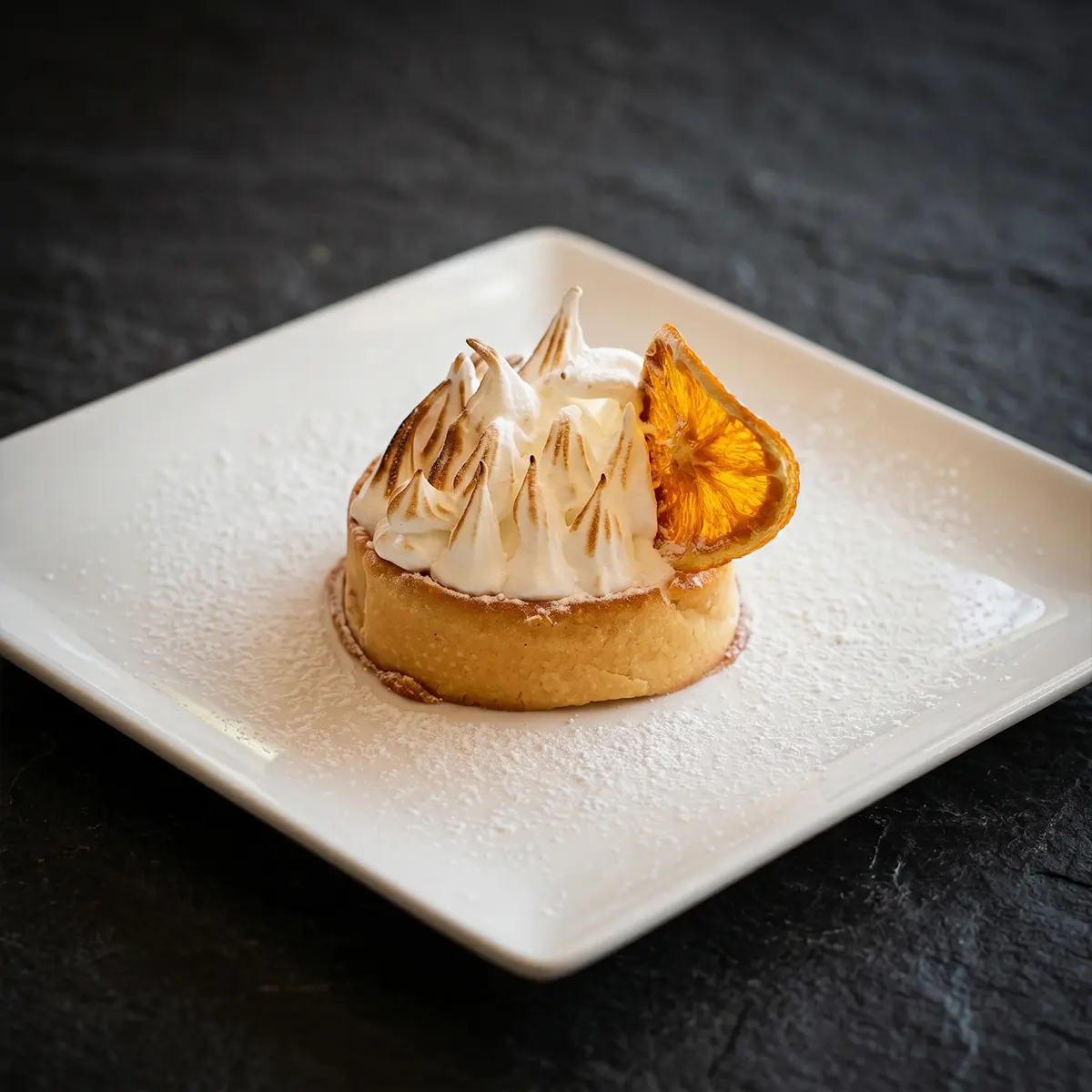 Lemon meringue tart with torched meringue and candied orange